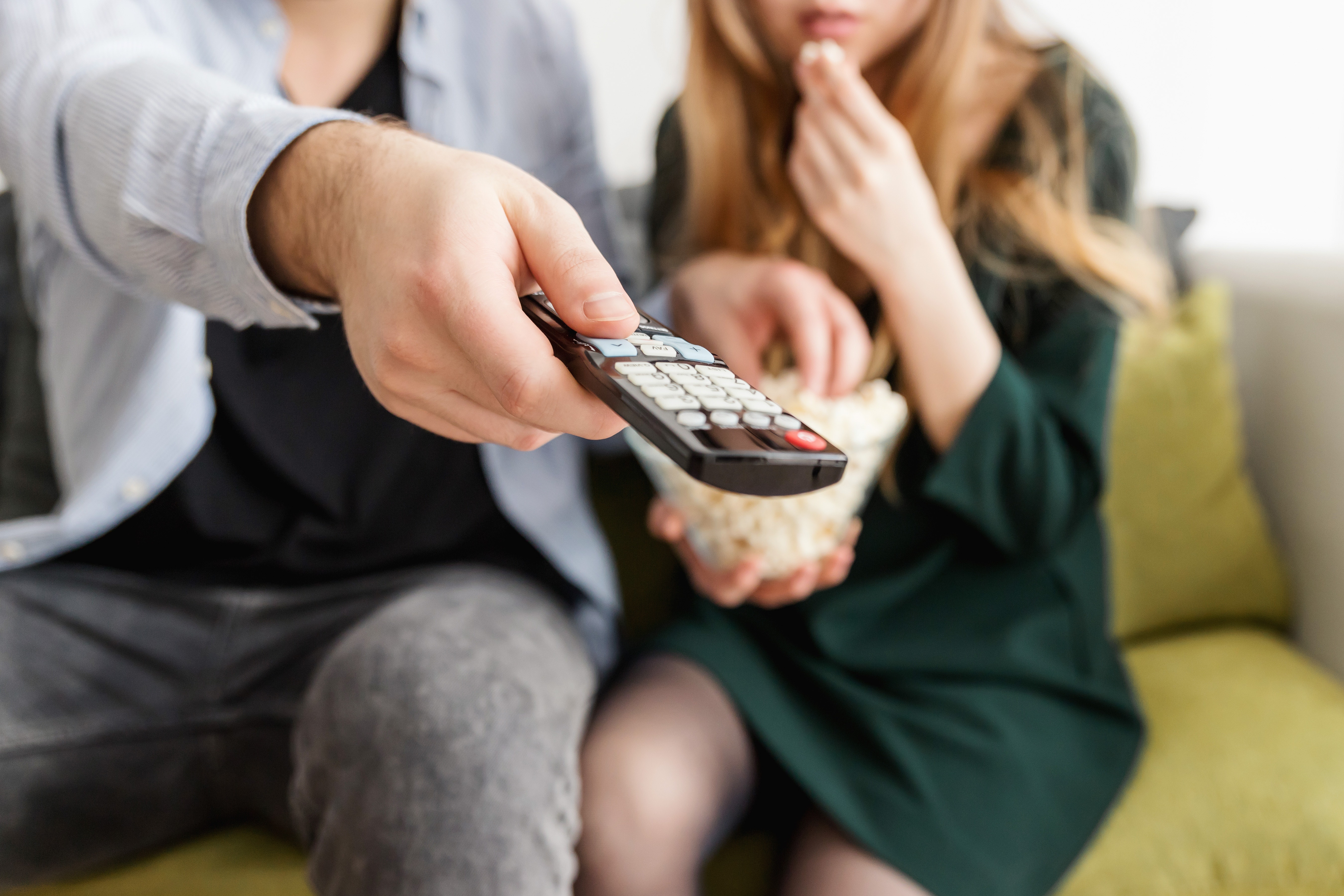 cohabitating couple watching tv with popcorn